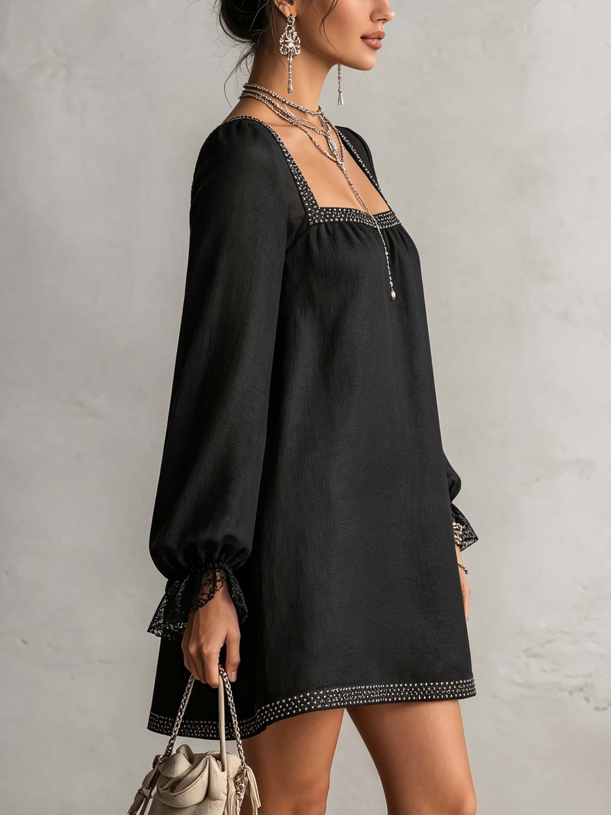 Mini-robe noire à encolure carrée, bordure en strass et poignets en dentelle